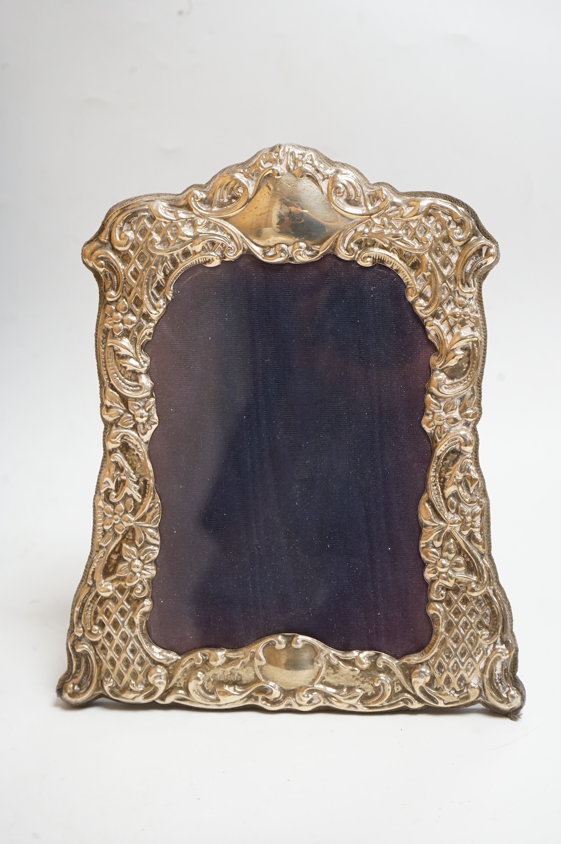 A George V silver mounted rectangular photograph frame, with ribbon bow crest, by Stokes & Ireland Ltd, Chester, 1912, 18.2cm including crest, together with ten other modern silver mounted photograph frames, largest 29.4